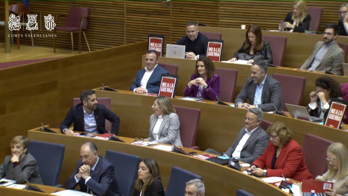 Bancada socialista en Les Corts con carteles de 'No a la Guerra'