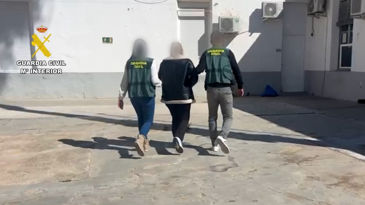 Agentes de la Guardia Civil junto a la detenida acusada de los robos.