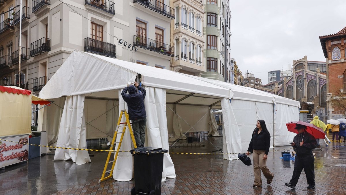 Operarios instalan carpas bajo la lluvia durante el montaje de las Fallas 2026, a 5 de marzo de 2026, en Valencia