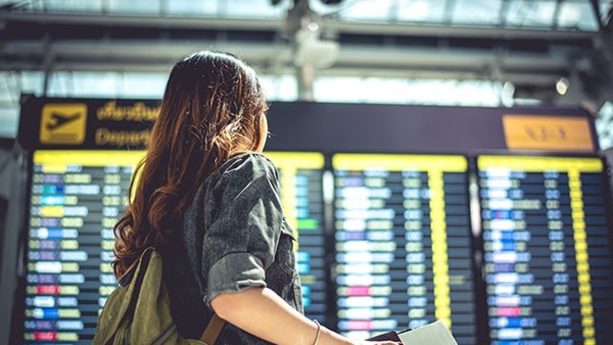 Una mujer recorre los pasillos de una aeropuerto internacional.