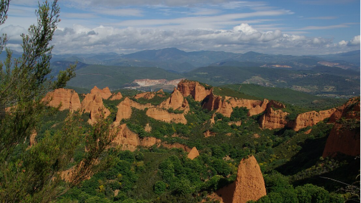 Formaciones rocosas rojizas entre bosque verde