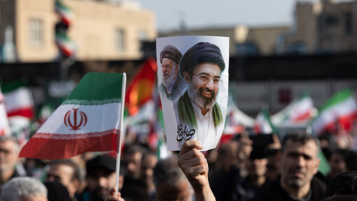 Un hombre sujeta un cartel con la imagen del nuevo líder supremo de Irán, Mojtaba Jamenei, junto a su padre, Alí Jamenei.