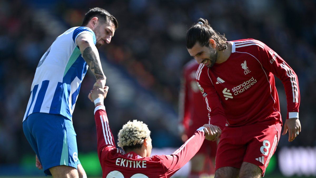 Ekitike es ayudado a levantarse tras un golpe durante el Brighton–Liverpool en el Amex Stadium. (Getty Images)