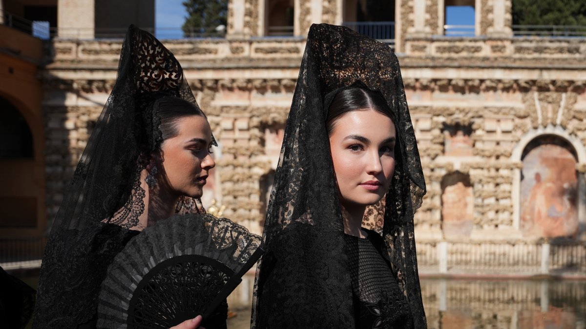 Modelos ataviadas con mantillas negras y diseños exclusivos desfilan por los jardines de Los Reales Alcázares.