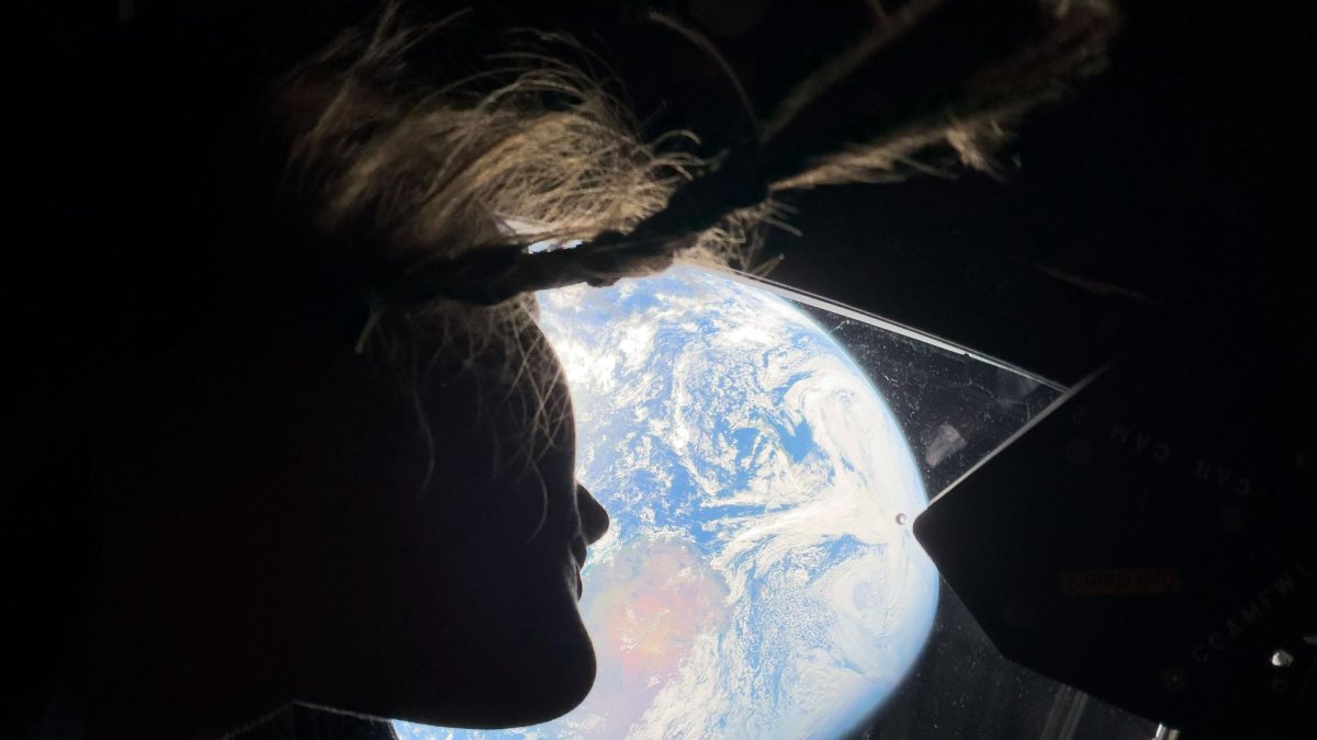 Christina Koch, observa la Tierra a través de una de las ventanas principales de la nave Orion.