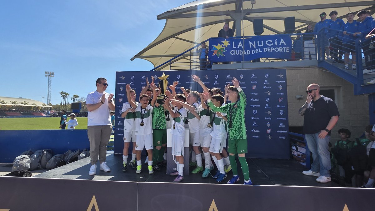 Los jóvenes jugadores de categoría benjamín del Elche recogen su trofeo.