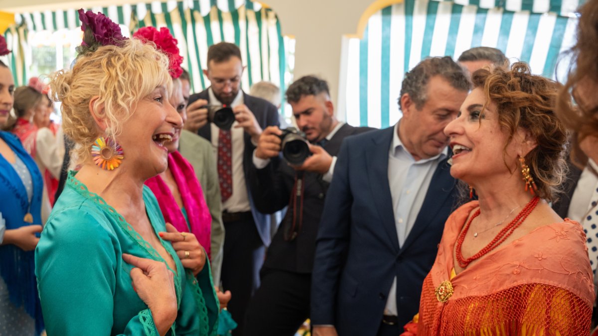 La secretaria general del PSOE-A, y candidata a la Junta de Andalucía, María Jesús Montero, saluda a Ángela Claverol, presidenta de Amama, en la caseta de Comisiones Obrera de la feria de Sevilla.