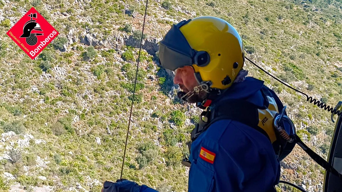 Un bombero del equipo de rescate, en el helicóptero, dispuesto a iniciar el rescate.