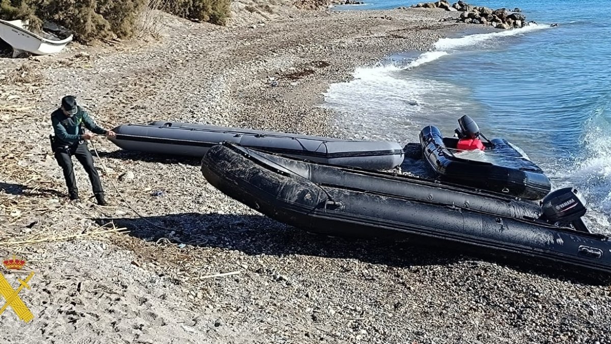 Un agente de la Guardia Civil remolca una de las embarcaciones intervenidas en las costas de Almería.