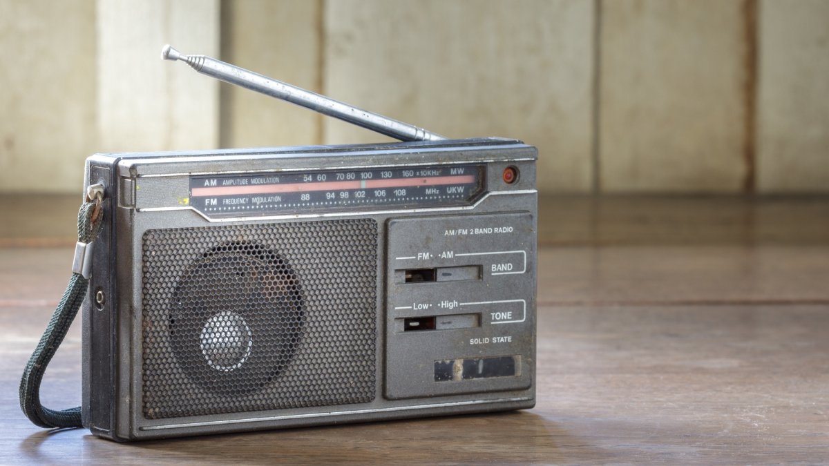 Old transistor radio on wooden background.