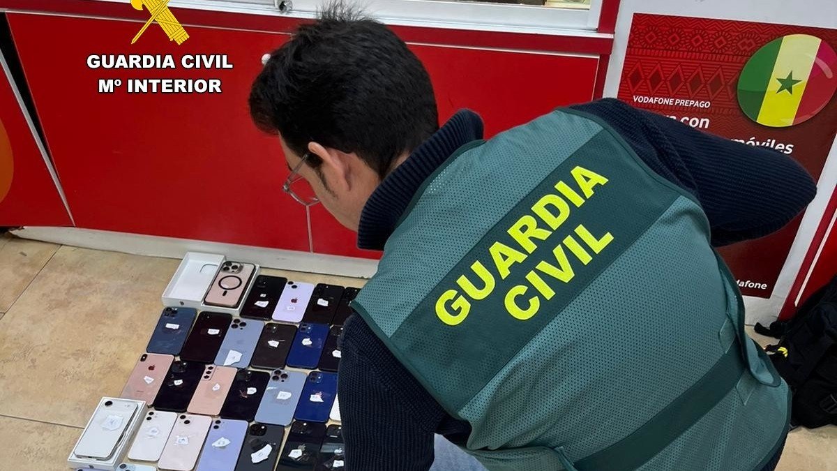 Agente de la Guardia Civil, con varios dispositivos recuperados durante la operación.