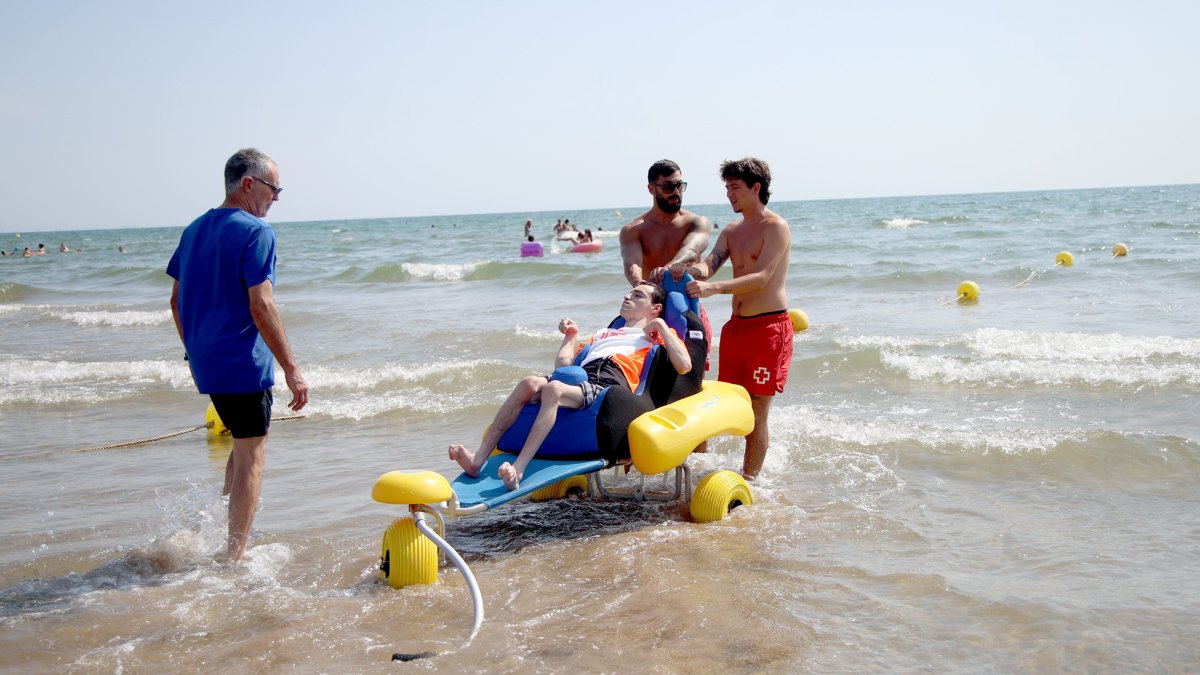 Iván prueba el nuevo sillón ergonómico adaptado durante la presentación del proyecto en la playa de El Cabanyal.