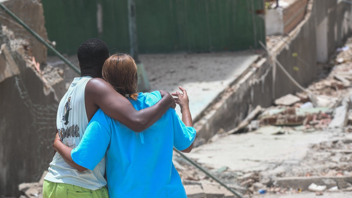 Dos personas observan un edificio derruido tras los terremotos en Venezuela.