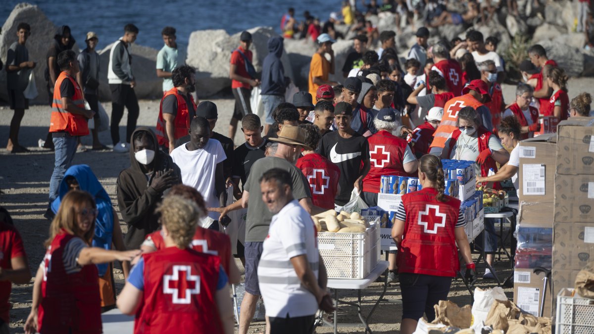 (Foto de ARCHIVO)
Miembros de la Cruz Roja reparten comida a los inmigrantes en una playa a 21 de agosto de 2026 en Ceuta