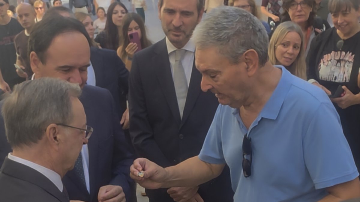 Un viandante regala un pin del Valencia CF al presidente de Ceuta, en Valencia