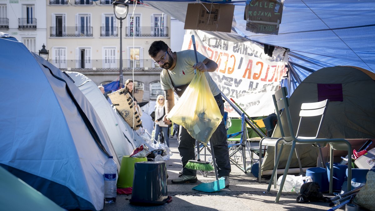 Un hombre recoge la basura en la acampada de Sol