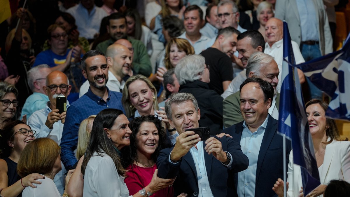 El presidente del Partido Popular, Alberto Núñez Feijóo, se hace un selfie durante un acto de precampaña, en el Palau de les Arts Reina Sofía de Valencia