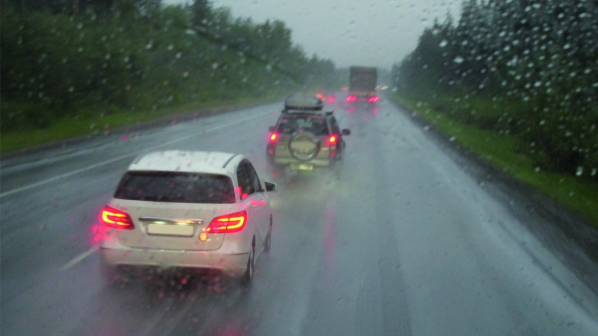 Coches circulando bajo una intensa lluvia