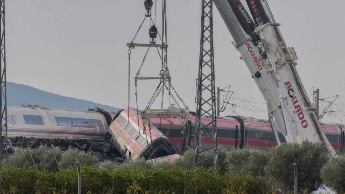 Dos grúas trabajan para retirar los vagones de los trenes accidentados