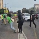 Momento en que el agente empuja a la mujer que se manifestaba.