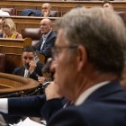 El líder de VOX, Santiago Abascal, habla por teléfono durante un pleno extraordinario en el Congreso de los Diputados.