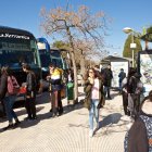 Estudiantes junto a los autobuses universitarios