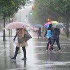 Varias personas caminan bajo la lluvia,.