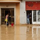 Varias personas limpian la zona afectada por el temporal