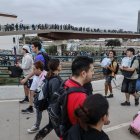 Decenas de personas en el puente que une València con La Torre, donde centenares de personas llegan de Valencia de abastecerse de agua y alimentos mientras otras salen de ayudar