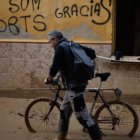 Hombre con una bicicleta entre el barro de la dana de Valencia