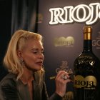 La actriz Belén Rueda firma una de las botellas especiales de Rioja del centenario.