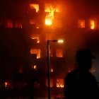 Un agente observa el edificio en llamas, en el barrio de Campanar, a 22 de febrero de 2024