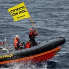 Activistas de Greenpeace en una lancha motora lanzan el mensaje 'Dejen de perforar, empiecen a pagar'.