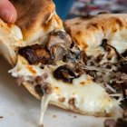 Pizza blanca trufada recién sacada del horno, con queso fundido y champiñones