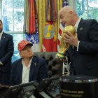WASHINGTON, DC - AUGUST 22:   FIFA President Gianni Infantino shows U.S. President Donald Trump the World Cup Trophy in the Oval Office while Vice President JD Vance looks on August 22, 2025 in Washington, DC.  Trump announced the FIFA World Cup 2026 draw will take place at The Kennedy Center.   (Photo by Chip Somodevilla/Getty Images)