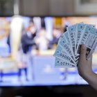 Boletos de lotería frente a la televisión