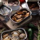 Selección de conservas premium con mejillones, sardinas, vieiras y calamares, un festín marino listo para abrir y disfrutar.