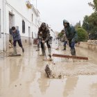Vecinos de Villanueva Mesía (Granada) se afanan en sacar el agua y barro de sus casas tras la crecida del Río Genil.