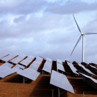 Campo con placas solares y un molino