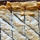 El baklava de pistacho preparado por José Andrés antes de añadir el almíbar, con las capas de masa filo marcadas en su clásico corte en rombos.