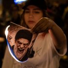 Una mujer quema la foto que representa el régimen de los ayatolás durante la concentración del movimiento ‘Mujer, Vida, Libertad’ en Barcelona.