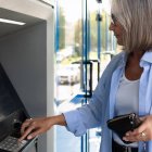 Una mujer utiliza un cajero automático para retirar dinero en efectivo, una práctica habitual que sigue generando dudas legales sobre los límites del efectivo en España.