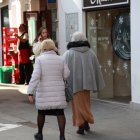 Dos personas caminan por una calle comercial, en una imagen de archivo.