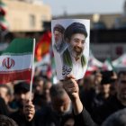 Un hombre sujeta un cartel con la imagen del nuevo líder supremo de Irán, Mojtaba Jamenei, junto a su padre, Alí Jamenei.