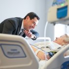 Juanma Moreno con una paciente ingresada en un hospital de Sevilla este lunes.
