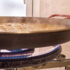 El arroz se cocina lentamente en la paellera mientras el caldo se reduce y concentra todo el sabor del plato
