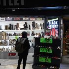 Varias personas pasan por delante de los comercios que anuncian los descuentos del Black Friday. 
Jesús Hellín / Europa Press
23/11/2022