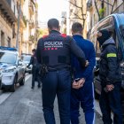 Un agente de los Mossos d'Esquadra se lleva a un detenido durante un operativo policial