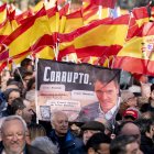 Manifestante porta pancarta con lema 'Pedro Sánchez corrupto' durante la concentración contra la corrupción del Gobierno convocada por el PP el 30 de noviembre de 2025.