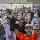 Varios jóvenes saludan tras su entrada desde Marruecos en Ceuta.